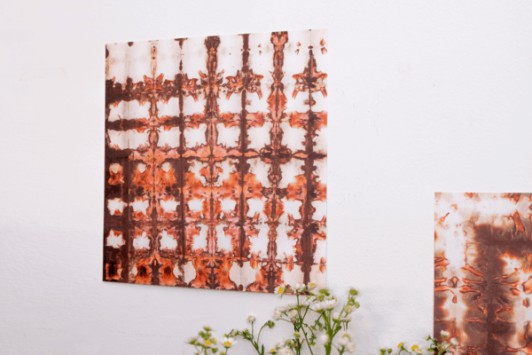 giclee print of a pear chromatogram on a wall with a small bouquet of flowers next to it