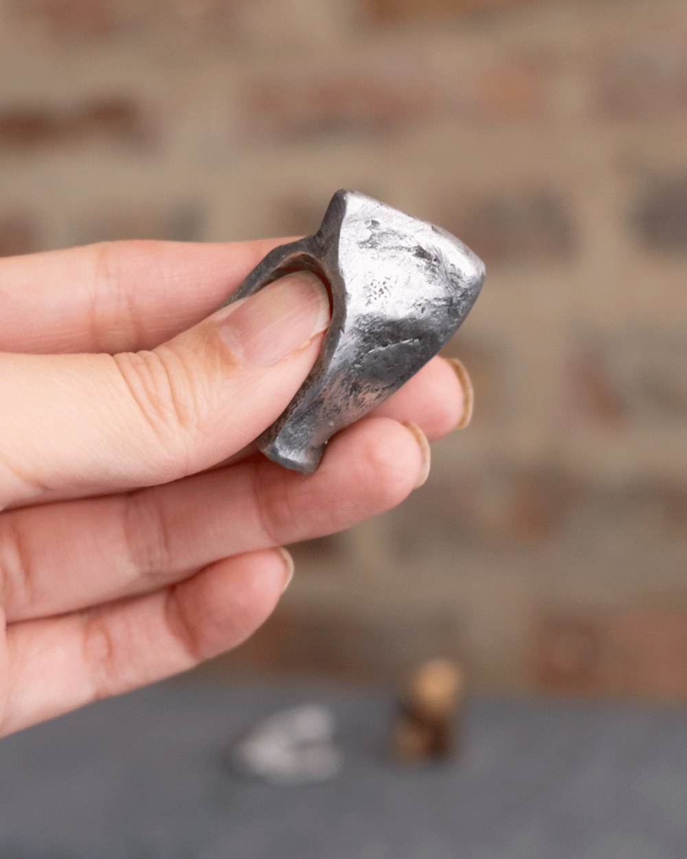 gif of light skinned fingers holding an aluminum fidget toy in different positions